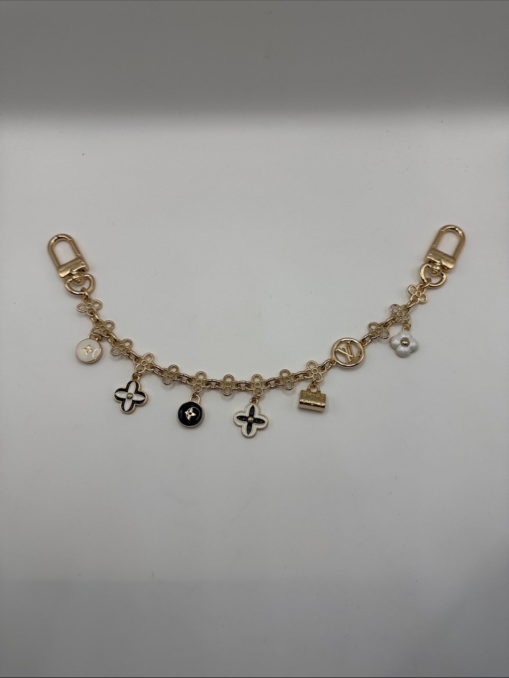 1431. Gold-Tone Floral Bag Charm with Black and White Accents 13”